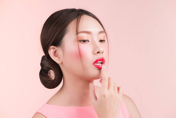 Gyönyörű ázsiai fiatal nő, divat smink elszigetelt rózsaszín. Kozmetika és smink - Fotó, kép