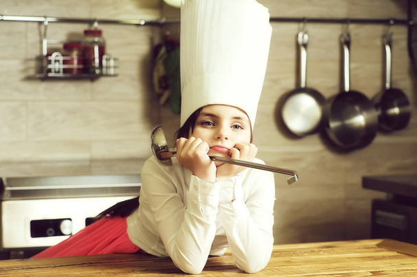 Girl in kitchen with ladle - Фото, изображение