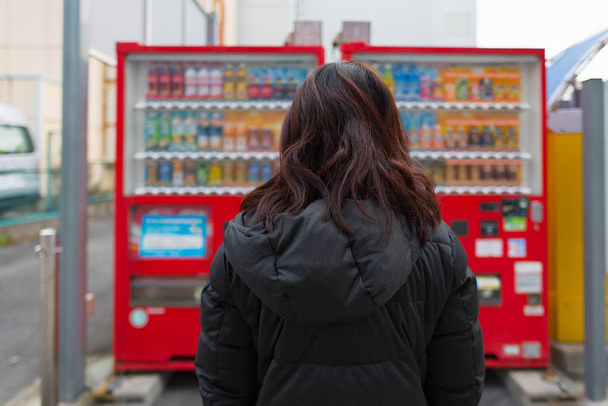 Lähikuva kaunis aasialainen nainen nauttia valitsemalla tuotteen automaatista Nagoya Japani
. - Valokuva, kuva