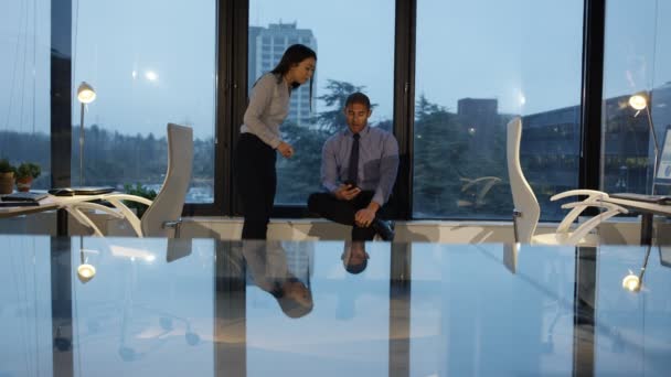 4K Business man and woman working late, chatting and looking at smartphone - Video