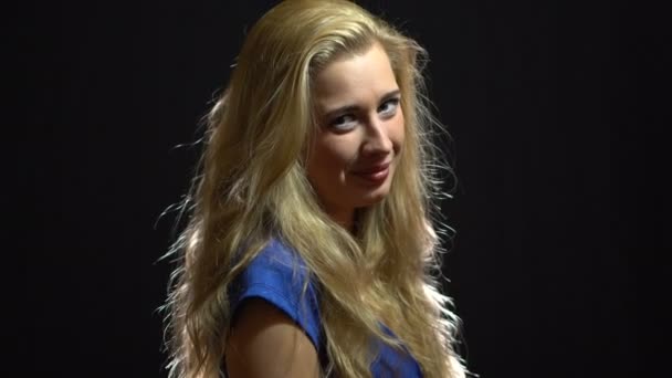 Krásná Sexy blondýnka dívka v modrých šatech je flirtuje a zve vás k jít s ní ve studiu s pozadím černá. - Záběry, video