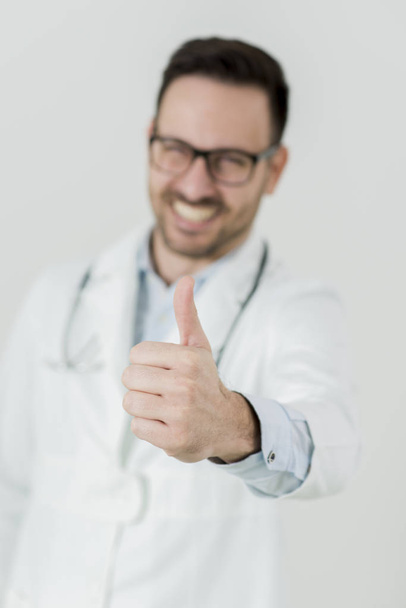 Portret van de jonge dokter met duim omhoog - Foto, afbeelding