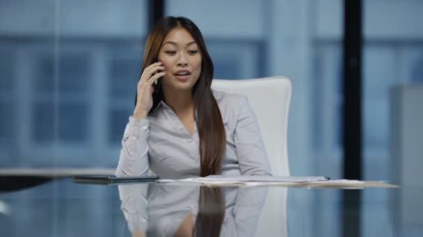 4K alegre mujer de negocios en la oficina hablando por teléfono y mirando el papeleo
. - Metraje, vídeo