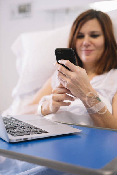 ill woman with Smartphone and laptop in the hospital - Foto, Bild