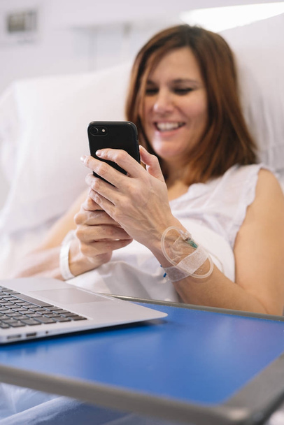 ill woman with Smartphone and laptop in the hospital - Foto, Imagen