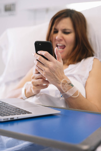 femme malade avec Smartphone et ordinateur portable à l'hôpital
 - Photo, image