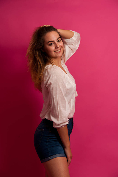 Cute young woman in light summer clothes over pink background - Foto, Bild
