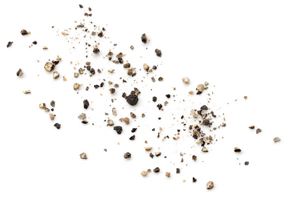 Aplastados granos de pimienta negra esparcidos sobre fondo blanco
 - Foto, Imagen