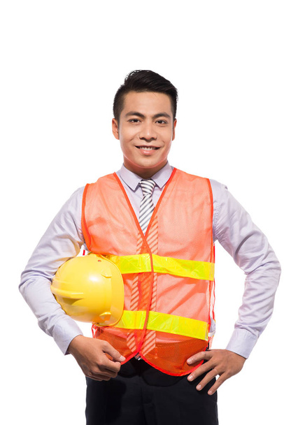 Young engineer with yellow helmet is isolated on white background. - Foto, Imagen