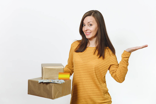Beautiful caucasian smiling young happy birthday woman in yellow clothes holding credit card, lot of cash money, golden gift boxes with present, celebrating holiday party on white background isolated. - Φωτογραφία, εικόνα