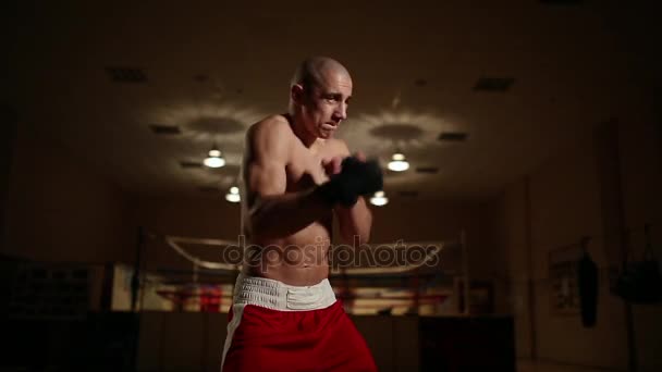 A professional boxer in the background of the ring holds shadow close-up. - Кадри, відео