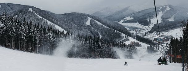 Blick auf das Skigebiet Bukovel vom Skilift, Schnee, Berge und Bäume im Hintergrund. Bukovel ist einer der beliebtesten Wintersportorte in der Ukraine. - Foto, Bild