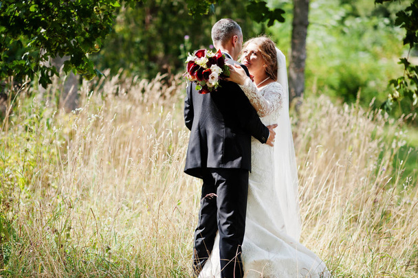 Romântico lindo casal recém-casado posando no parque pelo m
 - Foto, Imagem
