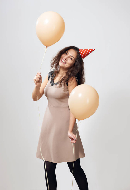 šťastná mladá žena nebo teen dívka v hnědé šaty s helia s vrtulovým pohonem - Fotografie, Obrázek