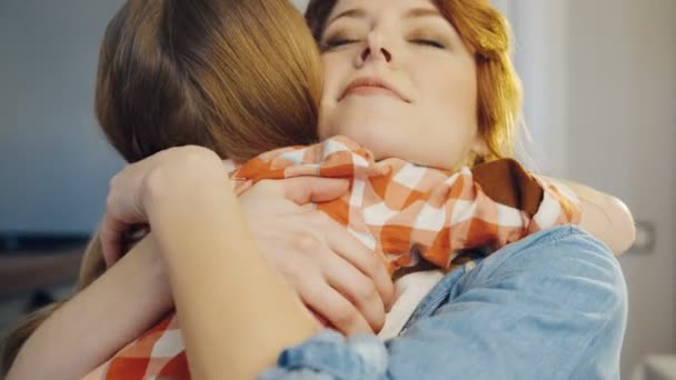 Portrait shot of the attractive young caucasian woman hugging a little girl who coming to her tight. Rear of the girl. Close up. Indoors - Imágenes, Vídeo