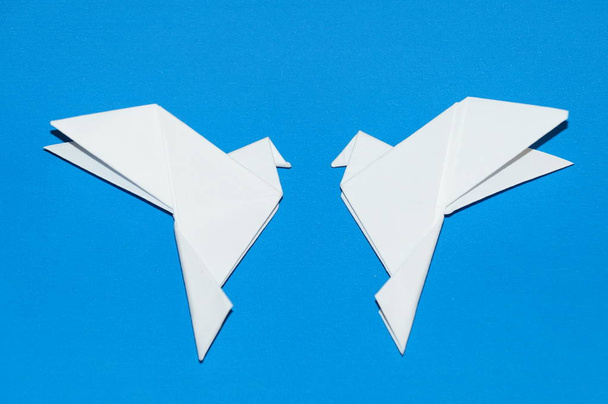 Origami galambok elszigetelt kék háttér. - Fotó, kép