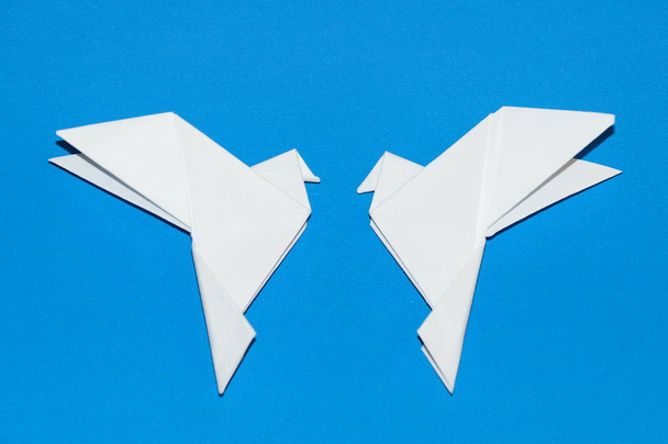Origami kyyhkyset eristetty sinisellä pohjalla
. - Valokuva, kuva