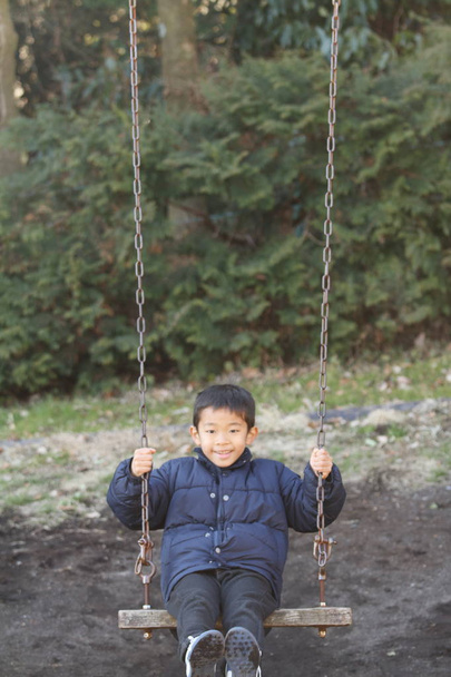 Ιαπωνικό αγόρι με την κούνια (δεύτερου βαθμού στο Δημοτικό σχολείο) - Φωτογραφία, εικόνα