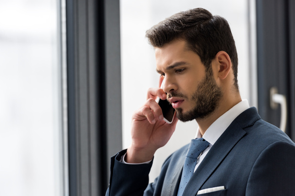 young businessman talking on smartphone in office - Фото, зображення
