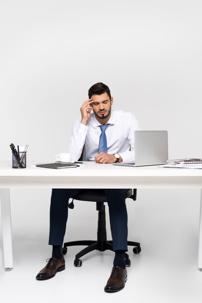 young businessman suffering from headache while sitting at workplace  - Zdjęcie, obraz