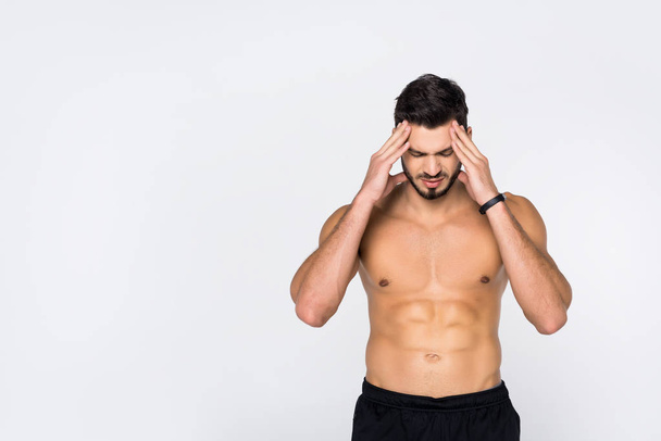 shirtless young sportive man with headache isolated on white - Foto, Bild
