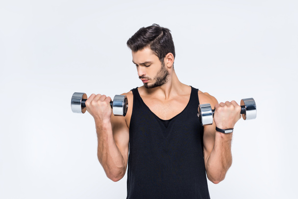 handsome young man working out with dumbbells isolated on white - Foto, Imagen