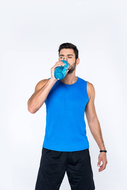 jovem bebendo água de garrafa de fitness isolado em branco
 - Foto, Imagem