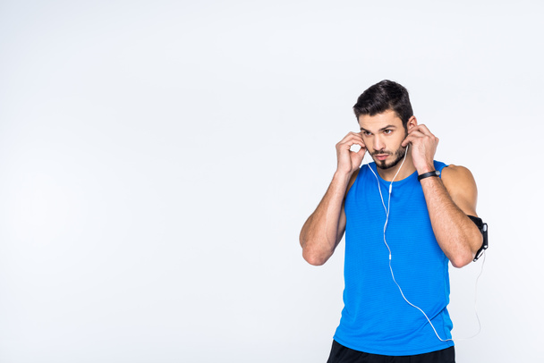 apuesto joven deportista con auriculares aislados en blanco
 - Foto, imagen