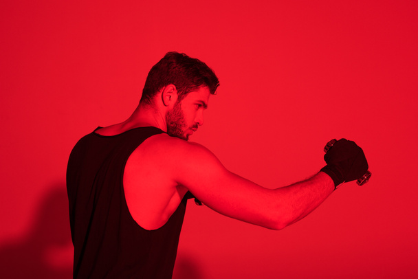 fiatal harcos kezével oldalnézetből borítják kötszereket, vörös fényben - Fotó, kép