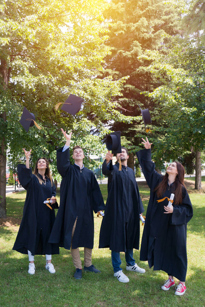 concepto de educación, graduación y personas - grupo de estudiantes internacionales felices en tablas de mortero y vestidos de soltero con diplomas - Foto, Imagen