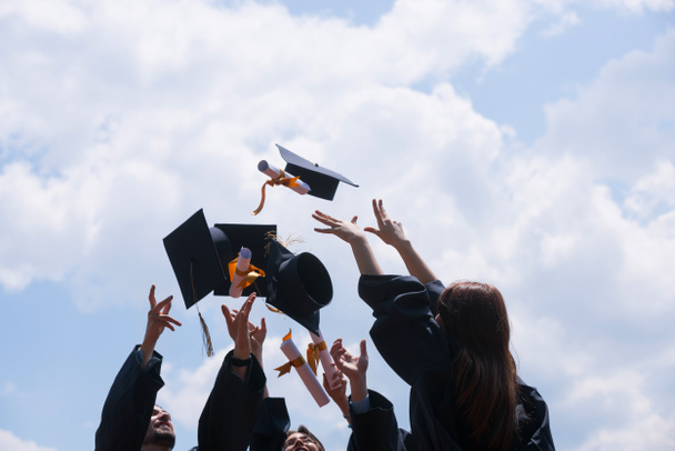 education, graduation and people concept - group of happy international students in mortar boards and bachelor gowns with diplomas - Foto, imagen