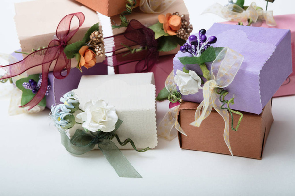 Tipo especial de caixas de presente com fita e flores na parte traseira branca
 - Foto, Imagem