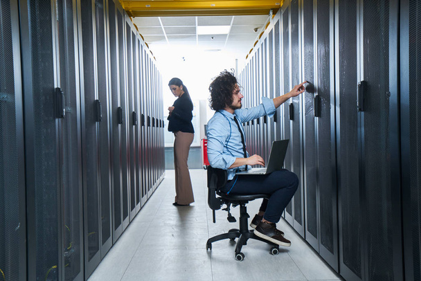 twee jonge technici werken bij een datacenter over het serveronderhoud - Foto, afbeelding