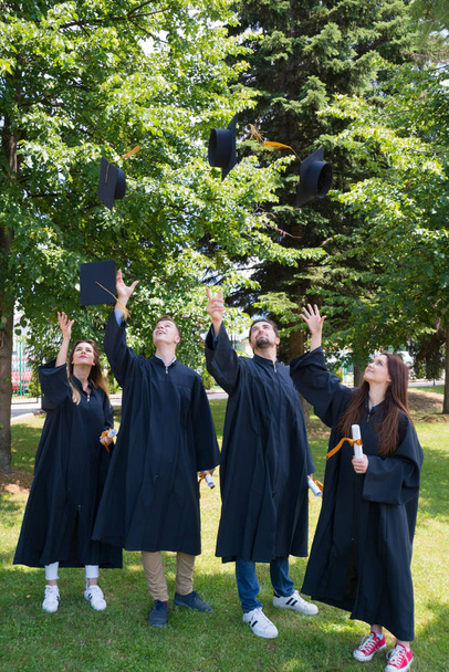 educação, graduação e conceito de pessoas - grupo de estudantes internacionais felizes em placas de argamassa e vestidos de solteiro com diplomas - Foto, Imagem