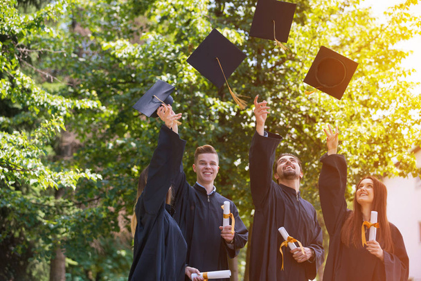 educação, graduação e conceito de pessoas - grupo de estudantes internacionais felizes em placas de argamassa e vestidos de solteiro com diplomas - Foto, Imagem