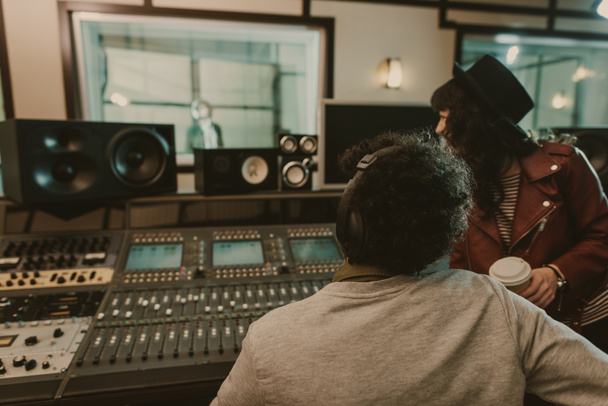 sound producers looking at singer at recording studio - Photo, Image