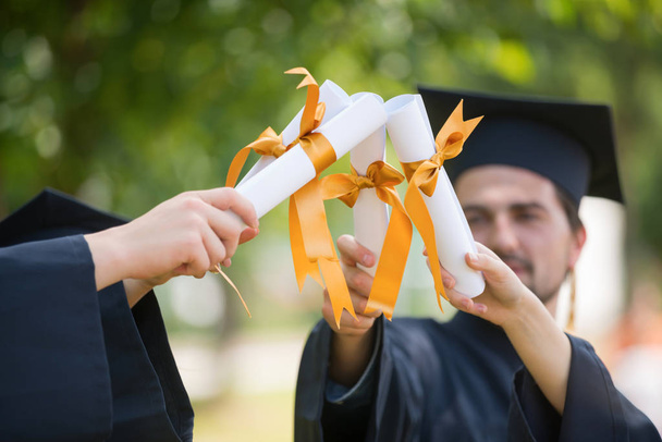 Bildung, Graduierung und People-Konzept - Gruppe glücklicher internationaler Studenten in Mörtelbrettern und Bachelorkleidern mit Diplomen - Foto, Bild