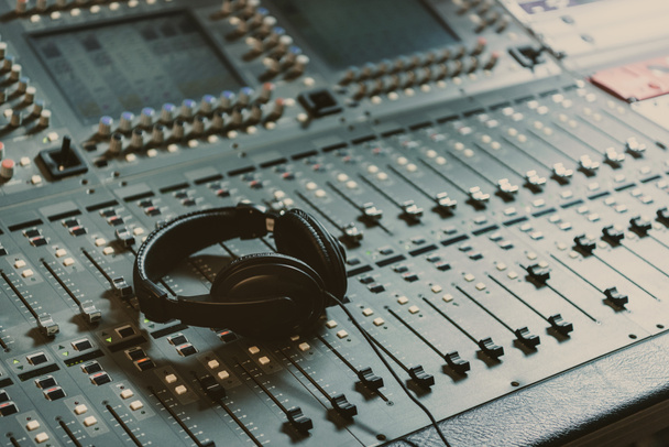 headphones on graphic equalizer at recording studio - Photo, Image