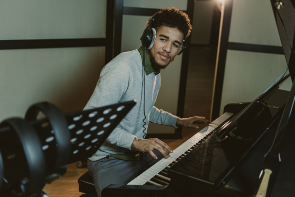 guapo sonriente pianista realizando canción
 - Foto, Imagen