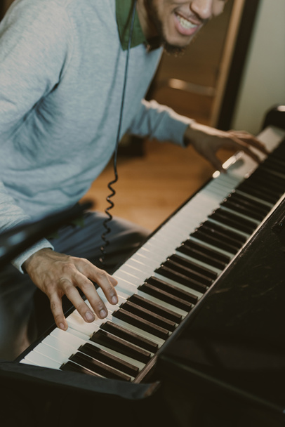 обрезанный кадр улыбающегося пианиста, исполняющего музыку
 - Фото, изображение