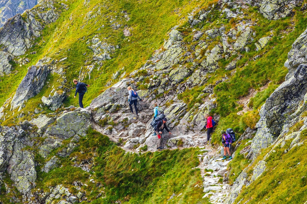 Montañas Tatra, Polonia, 14 de agosto de 2017: grupo de excursionistas no identificados descansando y agotados en el paso Krzyzne en las montañas Altas Tatra, Polonia
 - Foto, Imagen
