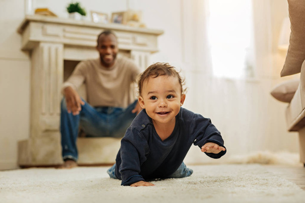 Smiling father watching his son crawling - Foto, Imagen