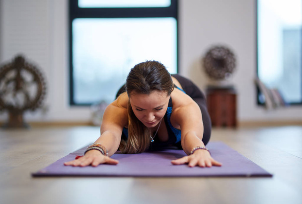 Young woman yoga practitioner or trainer indoor in various poses (asanas) - Foto, Imagem
