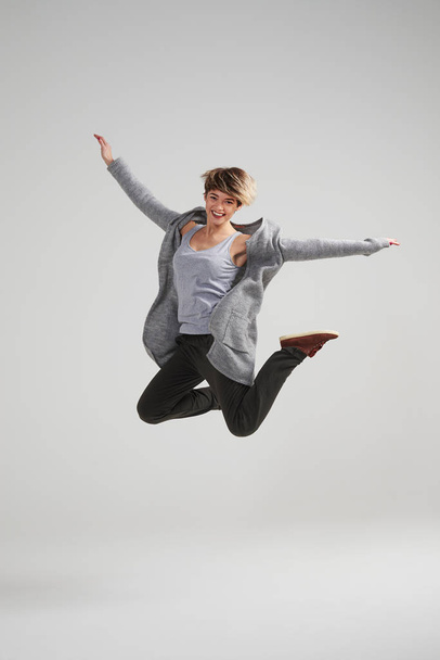 Жінка стрибає вгору в збудженні з піднятими руками
 - Фото, зображення