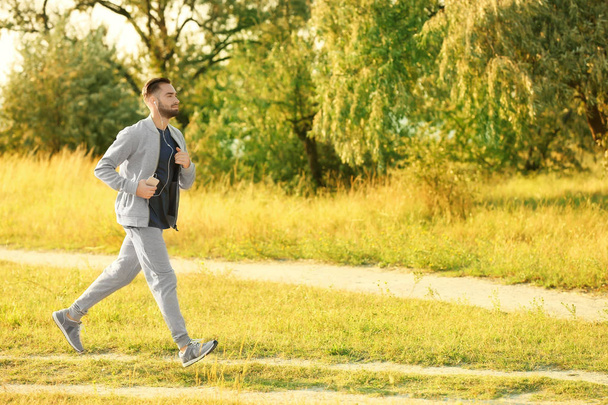 Sporty young man running outdoors - Valokuva, kuva