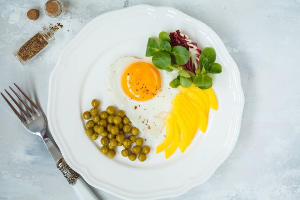 Жареное яйцо, зеленый горох, кукуруза салата и перец. Вид сверху
.  - Фото, изображение