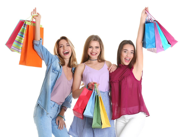 Happy young women with shopping bags on white background - Foto, Bild