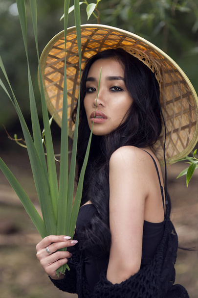 young sexy Vietnamese girl in a straw hat in a tropical forest - Fotografie, Obrázek