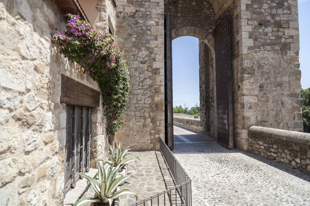 Οδός Δείτε και τον πύργο αψίδα του ρωμανικός γέφυρα στο μεσαιωνικό χωριό των Besalu, Καταλονία, Ισπανία. - Φωτογραφία, εικόνα