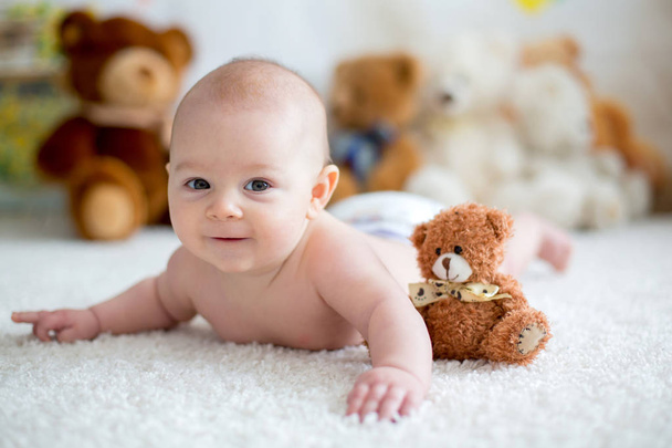 Little baby boy playing at home with soft teddy bear toys - Valokuva, kuva